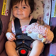 Ellaney is registered to the contest to win money with this photo: baby, child, infant, car_seat, safety_harness, plush_toy, sheep_toy, smiling, portrait, sitting, indoors, vehicle, floral_pattern, pink, brown_hair, bare_feet, infant_clothing, seat_belt, cozy, photography