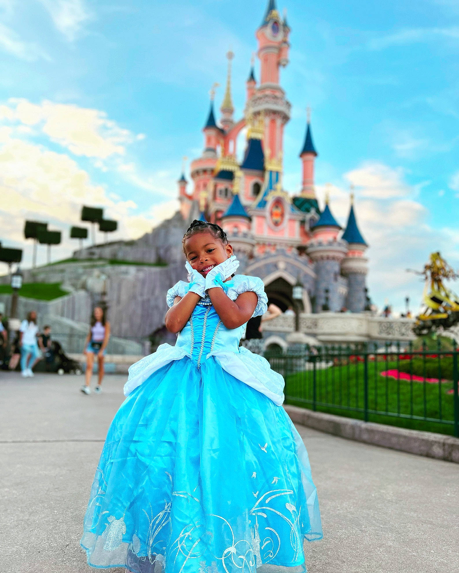Tiana a rejoint le concours — aidez-le/la à gagner de superbes lots ! building, castle, cloud, dress, event, fashion_design, fence, formal_wear, fun, gown, happy, joy, leisure, nonbuilding_structure, person, plant, recreation, sky, summer, travel