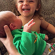 Kristie joined the competition — help win amazing prizes! toddler, baby, child, smiling, happy, holding, green_clothing, couch, patterned_background, family, newborn, hand, sitting, cute, portrait, indoor, people, love, together, siblings