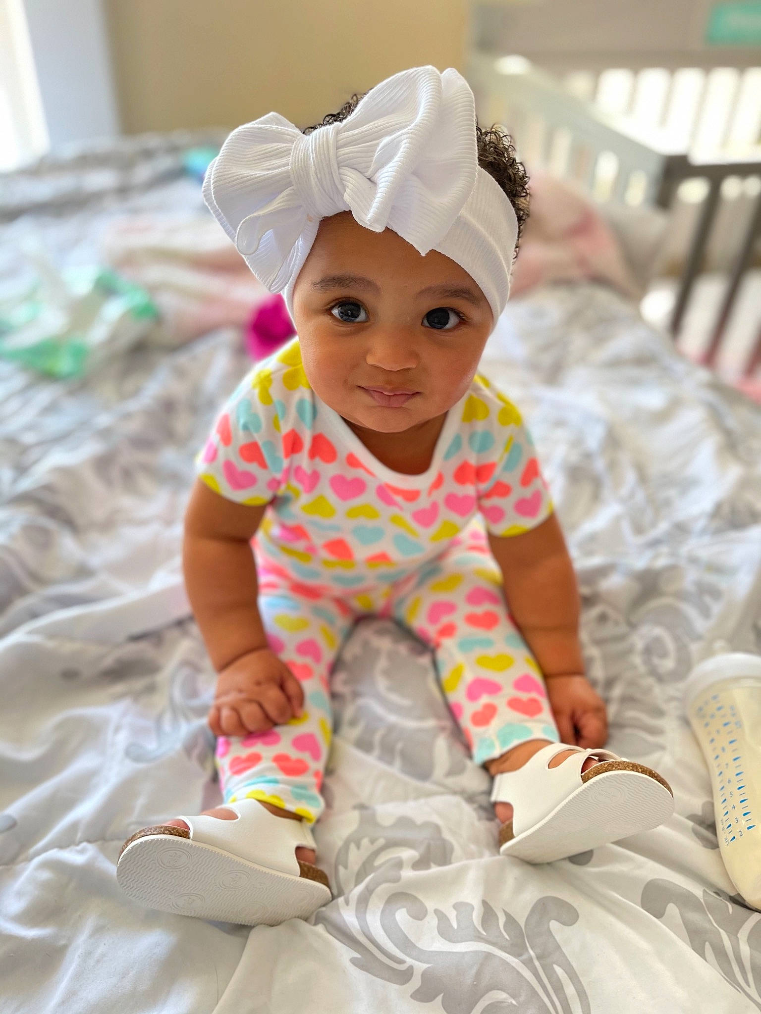 Penny is registered to the contest to win money with this photo: baby, baby_toddler_clothing, child, fashion_accessory, fun, hair_accessory, happy, headpiece, headwear, leisure, linens, pattern, person, pink, play, portrait_photography, recreation, sitting, sleeve, smile