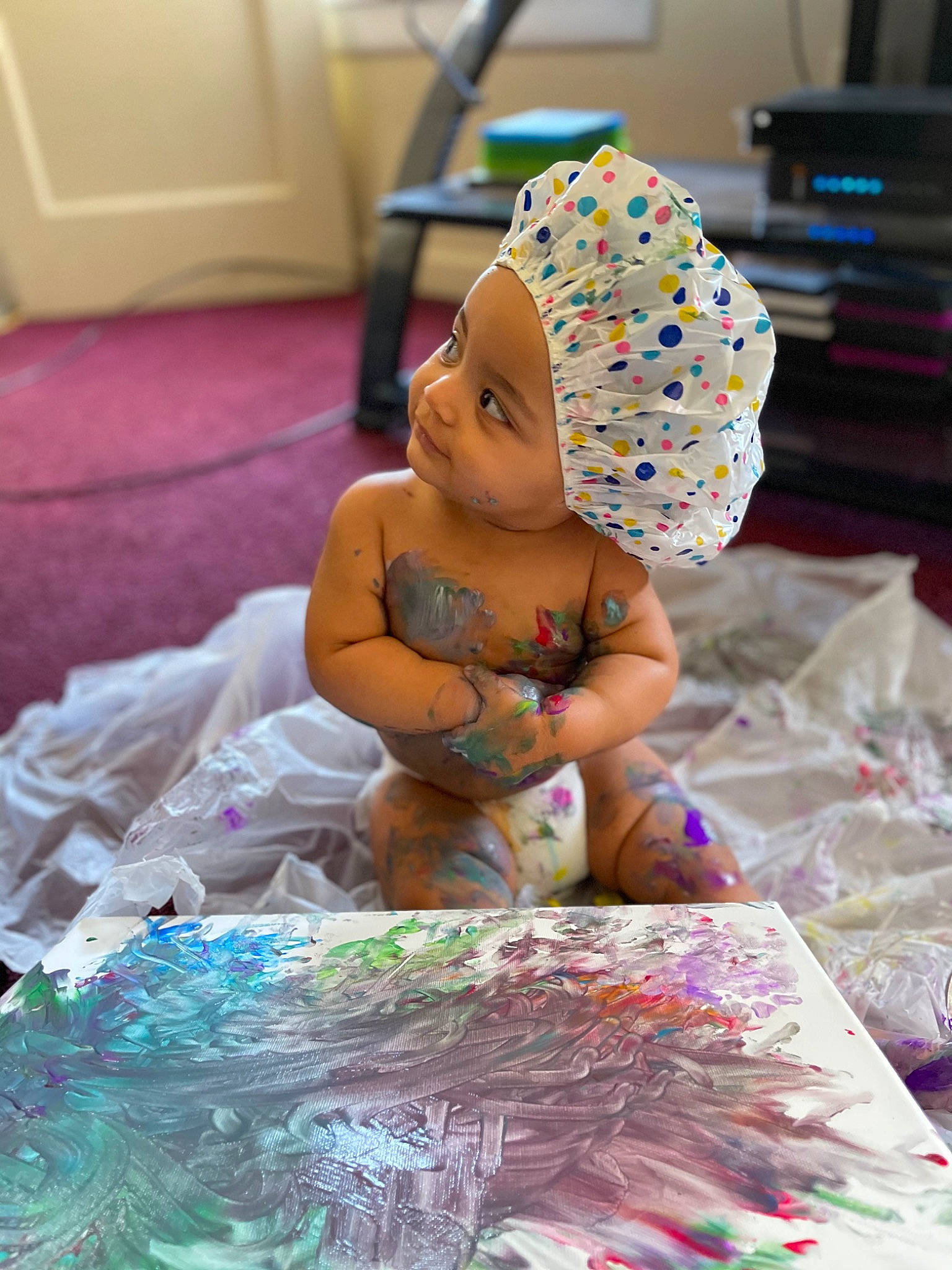 Penny is registered to the contest to win money with this photo: art, baby, baby_toddler_clothing, child, dress, event, fun, happy, hat, headwear, leisure, linens, party_supply, pattern, person, pink, purple, room, sitting, sun_hat