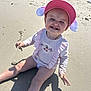 toddler, child, beach, sand, sunlight, cap, pink, smile, happy, seashell, shadow, sitting, casual_clothing, outdoor, summer, playful, person, toy, water_bottle, stroller