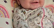 Braelyn joined the competition — help win amazing prizes! baby, babywear, child, clothing, colorful, cute, face, happy, indoors, infant, lying_down, onesie, pattern, person, pillow, portrait, rainbow, smiling, soft, unicorn