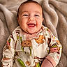 Braelyn joined the competition — help win amazing prizes! apparel, baby, blanket, child, cozy, cute, face, happy, head, indoors, infant, lying_down, onesie, playful, portrait, skin, sleepwear, smiling, soft_texture, young
