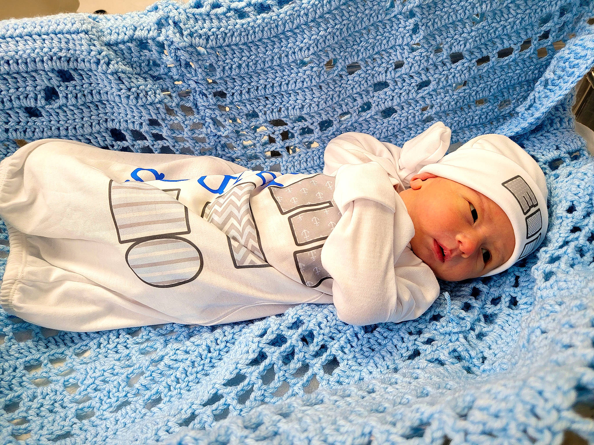 Eli Manning joined the competition — help win amazing prizes! baby, baby_products, baby_sleeping, baby_toddler_clothing, beanie, blue, cap, child, comfort, face, fashion_accessory, hat, headgear, headwear, human_body, knit_cap, linens, pattern, person, sleeve