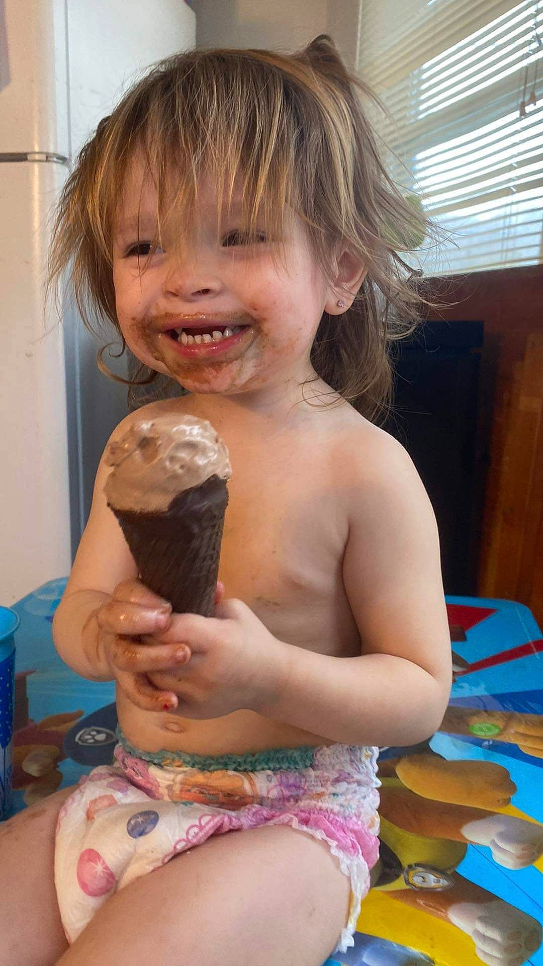 Adalynn is registered to the contest to win money with this photo: blond, brown_hair, child, curtain, dessert, drink, food, food_craving, frozen_dessert, fun, happy, human_leg, ice_cream, ingredient, joy, person, smile, sweetness, thigh, toddler