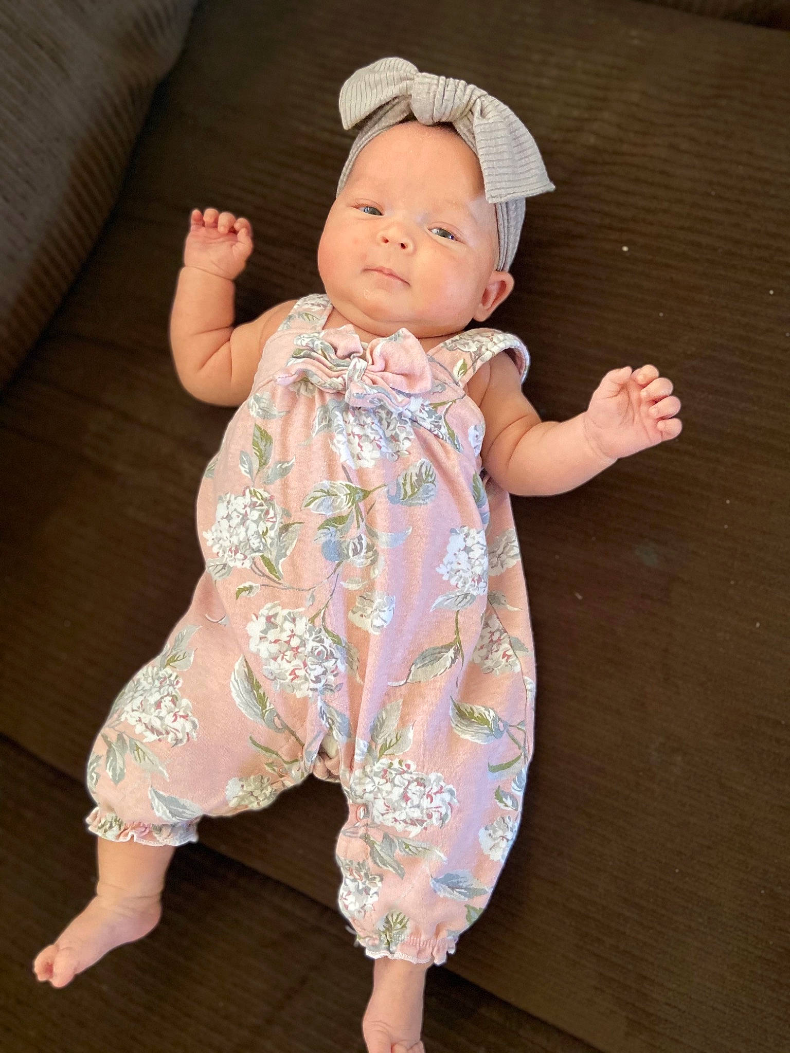 Finley is registered to the contest to win money with this photo: arm, baby, baby_toddler_clothing, barefoot, cheek, chin, dress, eye, face, hand, happy, head, one_piece_garment, pattern, person, pink, skin, sleeve, t_shirt, thumb