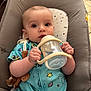 baby, infant, bottle, sippy_cup, blue_clothing, space_pattern, seat, cushion, indoor, child, cute, face, hand, looking_at_camera, young, home, floor, toy, comfort, expression