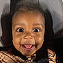 baby, child, smiling, tongue_out, car_seat, blanket, happy, face, seatbelt, striped_clothing, closeup, indoors, infant, cute, portrait, headrest, black_hair, wide_eyes, child_safety, cozy