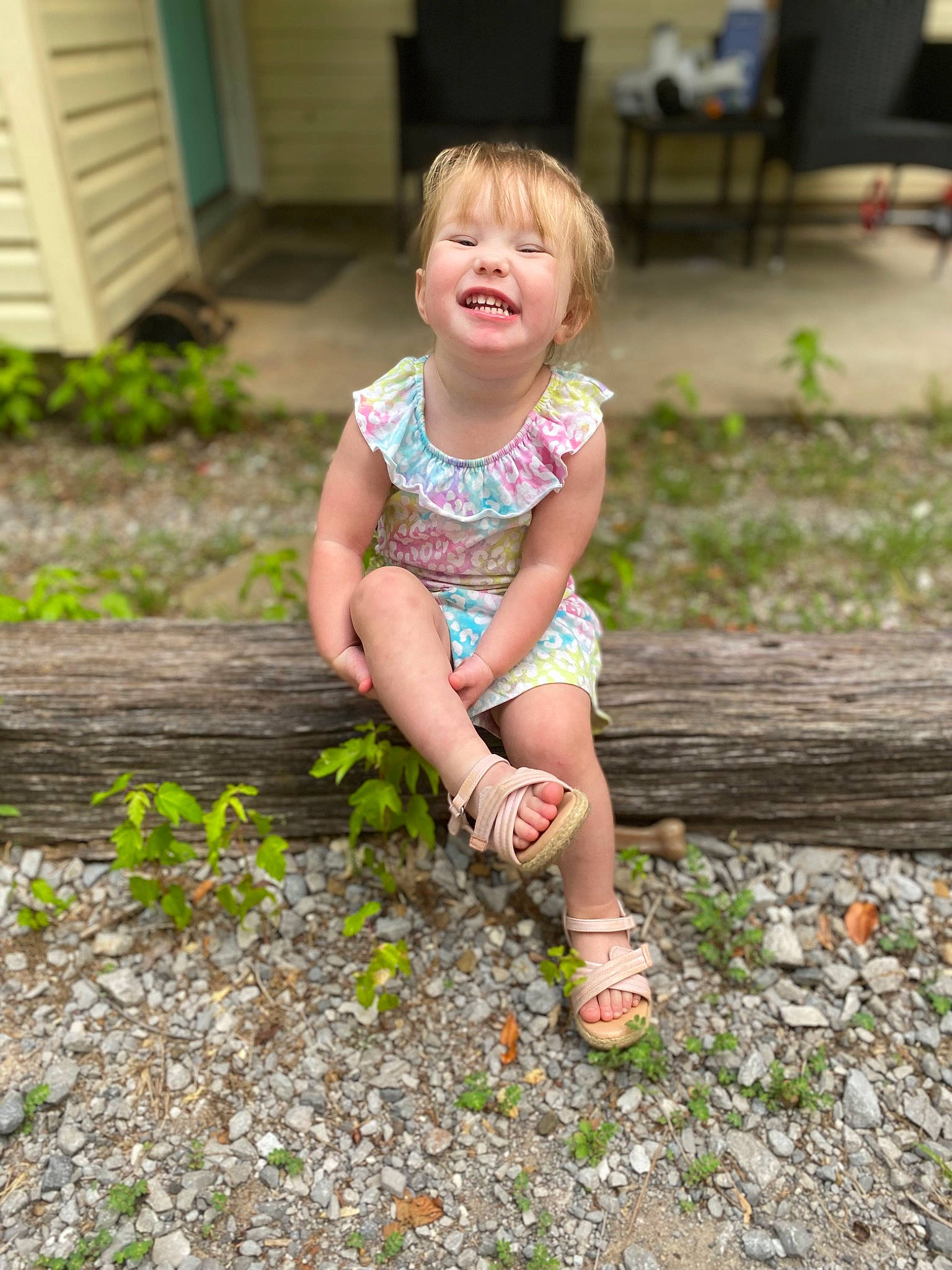 Rylee is registered to the contest to win money with this photo: child, eye, face, foot, fun, garden, grass, hair, happy, human_leg, joy, leisure, pattern, people_in_nature, person, plant, sandal, sitting, smile, thigh