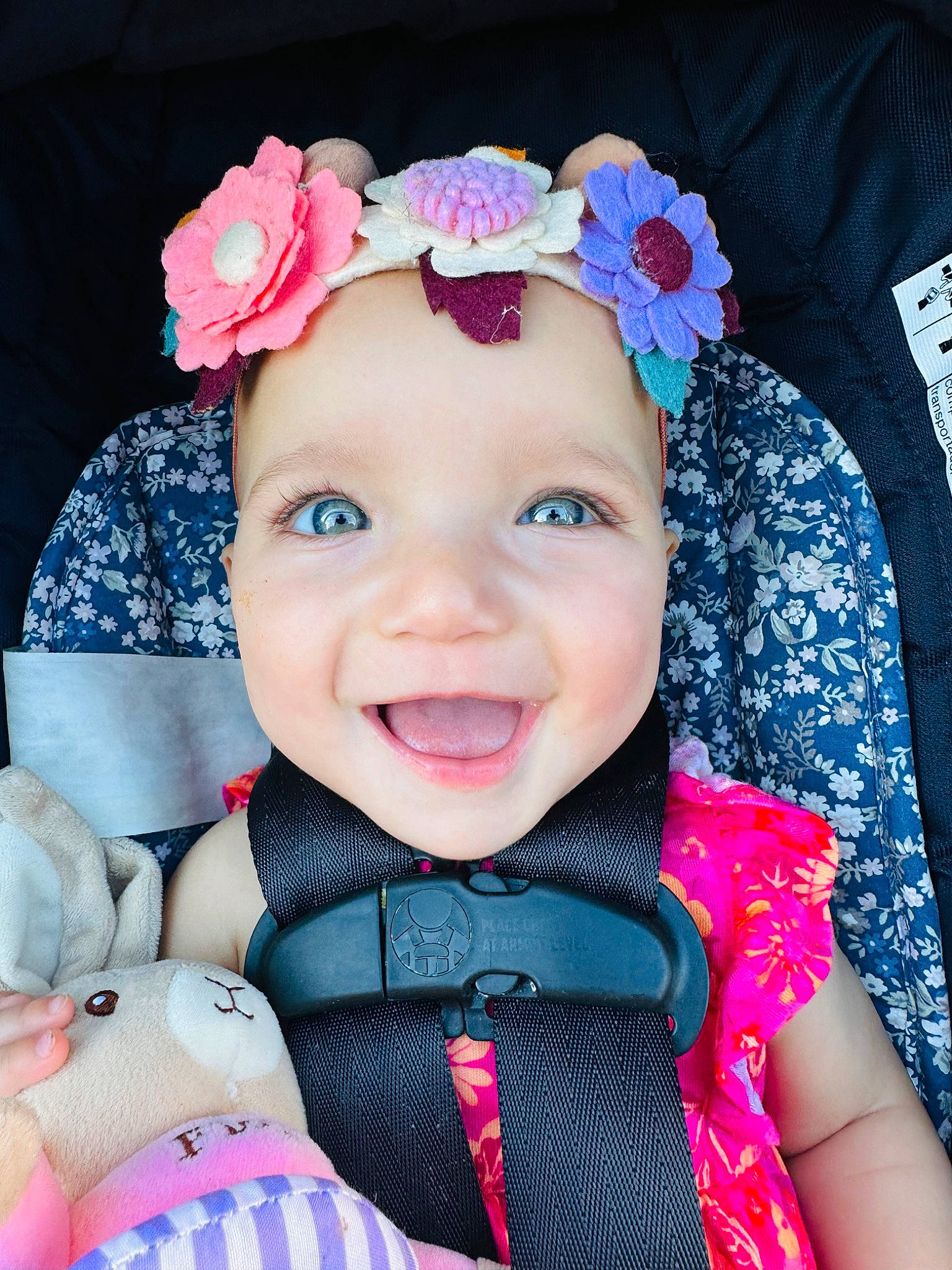 Astrid is registered to the contest to win money with this photo: baby, baby_toddler_clothing, cheek, face, facial_expression, happy, head, headgear, headwear, iris, joy, lip, person, pink, plant, product, purple, skin, sleeve, smile