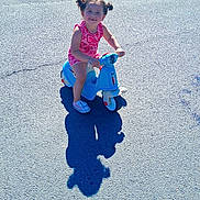 Valéntina a rejoint le concours — aidez-le/la à gagner de superbes lots ! blue_toy, casual, child, childhood, daylight, fun, hair_pigtails, happy, outdoor, pavement, person, pink_clothing, play, shadow, small_vehicle, smiling, summer, sunny, toddler, toy_scooter