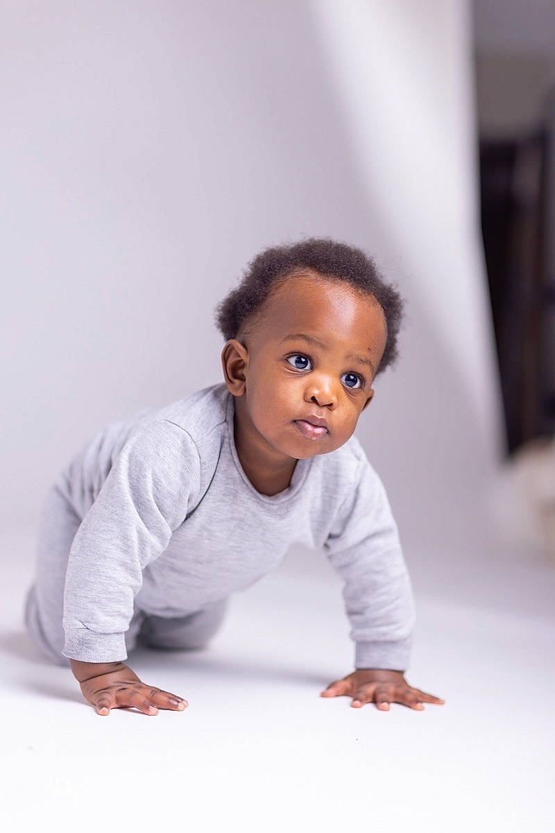 Rudi is registered to the contest to win money with this photo: baby, baby_toddler_clothing, cheek, child, face, fashion_design, flash_photography, floor, flooring, fun, happy, hardwood, head, person, portrait_photography, room, sitting, sleeve, t_shirt, toddler