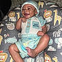 baby, smiling, infant, hat, clothing, cute, happy, child, portrait, lying_down, animal_print, cushion, indoor, buttoned_shirt, face, hand, foot, blue, patterned, toddler