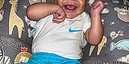 Blake joined the competition — help win amazing prizes! baby, smiling, happy, infant, clothing, white_shirt, blue_shorts, sitting, cushion, animal_print, giraffe, lion, playful, cute, child, indoors, portrait, joyful, face, person