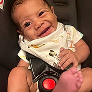 Blake joined the competition — help win amazing prizes! baby, smiling, car_seat, infant, bib, foot, hand, face, cute, happy, child, seat_belt, clothing, diaper, skin, person, portrait, indoor, closeup, expression