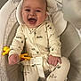baby, infant, smiling, laughing, onesie, toy, yellow_toy, baby_seat, safety_belt, cute, happy, child, indoor, cushion, face, hands, feet, clothing, playful, portrait