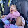 Aurora is registered to the contest to win money with this photo: baby, child, stroller, pink, striped_clothing, socks, happy, smiling, pigtails, outdoor, grass, seatbelt, cute, infant, person, head, face, hand, legs, footwear