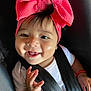 baby, child, smile, headband, pink_bow, car_seat, seatbelt, infant, happy, face, hand, white_shirt, cute, black_hair, portrait, closeup, young_child, skin, person, indoors