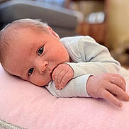 Brody joined the competition — help win amazing prizes! baby, infant, newborn, pillow, blanket, hand, eyes, face, lying_down, indoor, nursery, couch, soft, portrait, closeup, skin, clothing, cozy, gaze, small_fingers