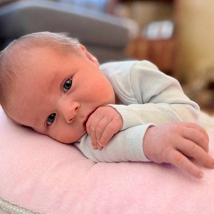 Brody joined the competition — help win amazing prizes! baby, blanket, closeup, clothing, couch, cozy, eyes, face, gaze, hand, indoor, infant, lying_down, newborn, nursery, pillow, portrait, skin, small_fingers, soft