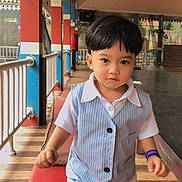 Ghazi is registered to the contest to win money with this photo: child, toddler, vest, shorts, indoor, pillars, red_mat, wooden_floor, railing, confident, walking, short_hair, white_shirt, play_area, cute, person, young_child, flooring, lighting, casual