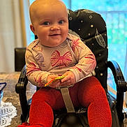 Piper joined the competition — help win amazing prizes! baby, child, high_chair, smile, red_tights, bow_pattern, indoor, table, snack, happy, cozy, cute, person, face, seated, home, bright_eyes, hands, clothing, infant