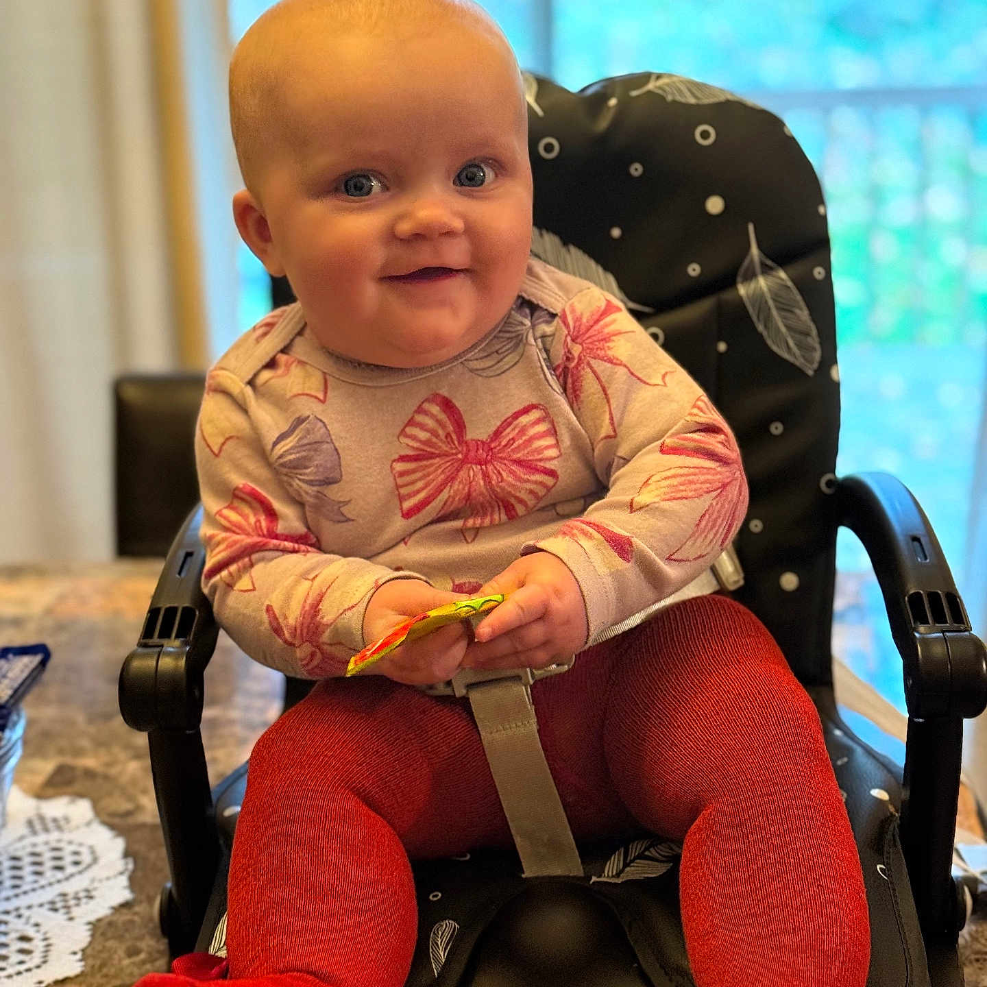 Piper joined the competition — help win amazing prizes! baby, bow_pattern, bright_eyes, child, clothing, cozy, cute, face, hands, happy, high_chair, home, indoor, infant, person, red_tights, seated, smile, snack, table