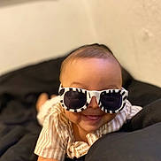 Joziah joined the competition — help win amazing prizes! baby, child, sunglasses, striped_sunglasses, smiling, tongue_out, lying_down, blanket, striped_clothing, cute, indoor, head, face, infant, young_child, fashion, playful, black_blanket, light_skin, happy