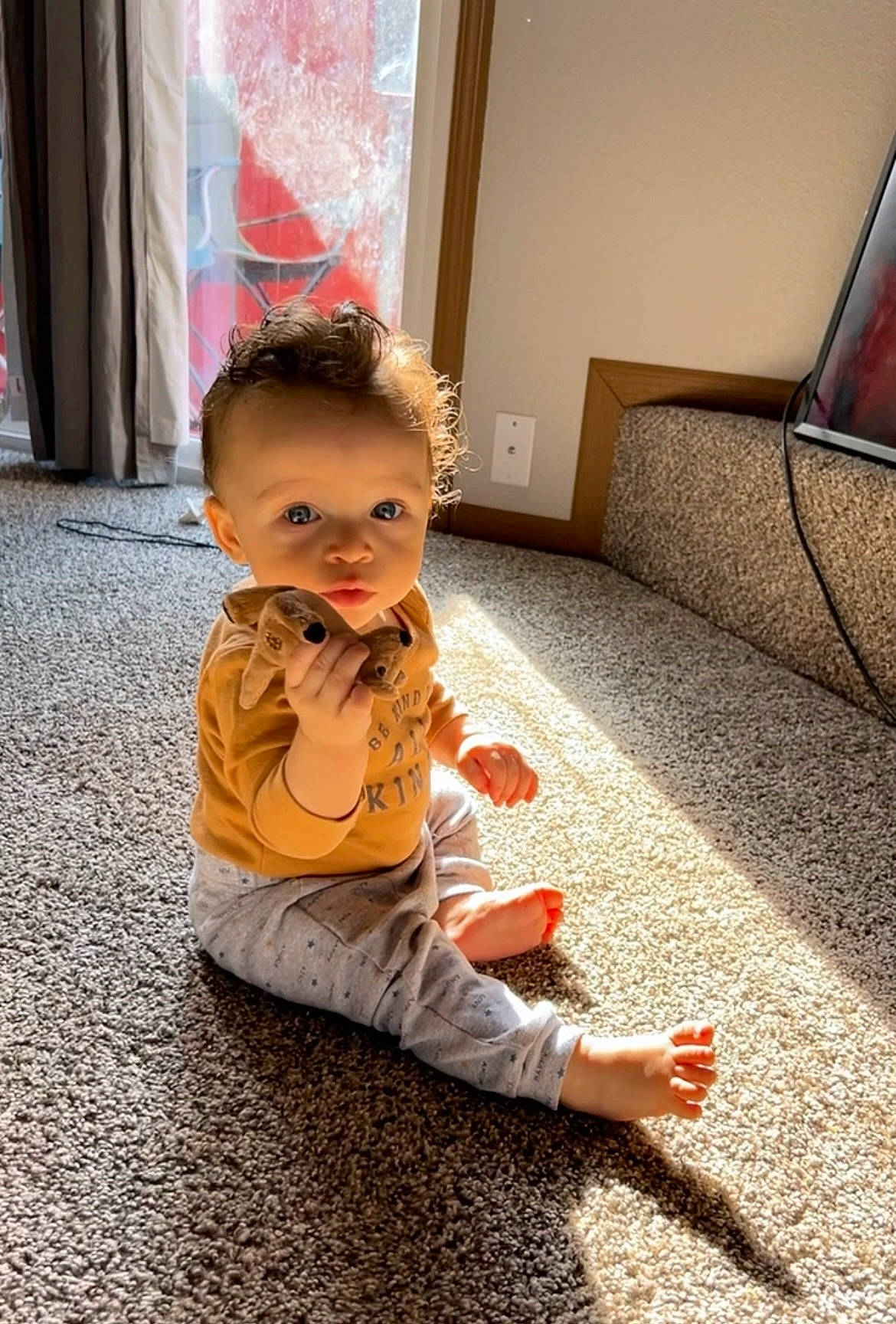 Legacy is registered to the contest to win money with this photo: baby, baby_toddler_clothing, carpet, child, comfort, curtain, floor, flooring, foot, fun, hardwood, human_leg, leisure, orange, person, road_surface, room, sitting, skin, toddler