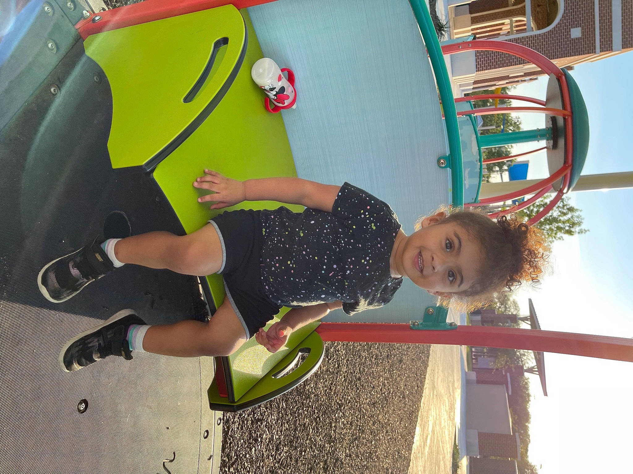 Athena is registered to the contest to win money with this photo: amusement_park, amusement_ride, child, city, fun, green, happy, helmet, joy, leisure, outdoor_play_equipment, person, personal_protective_equipment, play, playground, recreation, sky, smile, toddler, vacation