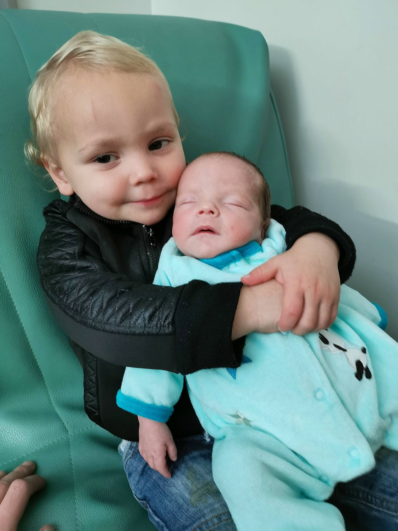 Mahel a rejoint le concours — aidez-le/la à gagner de superbes lots ! baby, baby_products, cheek, child, comfort, joy, mother, person, product, sibling, sitting, skin, smile, toddler, turquoise