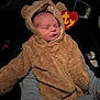 Kyren is registered to the contest to win money with this photo: baby, infant, sleeping, bear_costume, fuzzy_clothing, hood, car_interior, person, child, cute, warm, soft_texture, hands, young, cozy, animal_ears, zipper, seat, dark_background, resting