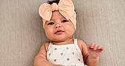 Kallie is registered to the contest to win money with this photo: baby, infant, headband, bow, cute, face, portrait, smiling, clothing, pattern, watermelon, white_outfit, texture, fabric, hand, skin, lying_down, adorable, child, soft_lighting