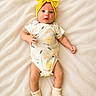Kallie is registered to the contest to win money with this photo: baby, infant, yellow_bow, headband, onesie, lemon_pattern, socks, blanket, lying_down, cute, soft_texture, child, newborn, portrait, indoors, small_hands, small_feet, expression, adorable, light