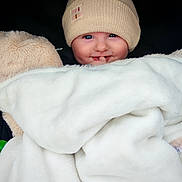 Lou participe au concours pour gagner de l'argent avec cette photo : baby, beanie, blanket, blue_eyes, child, closeup, cozy, cute, face, fingers, fluffy, happy, hat, indoors, infant, portrait, smile, soft, warm, wrapped