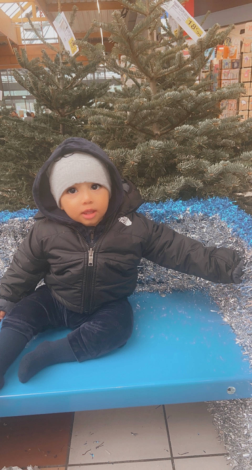 Amar participe au concours pour gagner de l'argent avec cette photo : child, city, electric_blue, freezing, fun, grass, happy, headwear, hoodie, jacket, leisure, person, personal_protective_equipment, plant, play, portrait_photography, recreation, sitting, soil, toddler