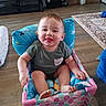 baby, baby_chair, child, clothing, colorful, cute, flooring, footwear, furniture, happy, home, indoor, person, pillow, playful, rug, sitting, smiling, tongue_out, toy