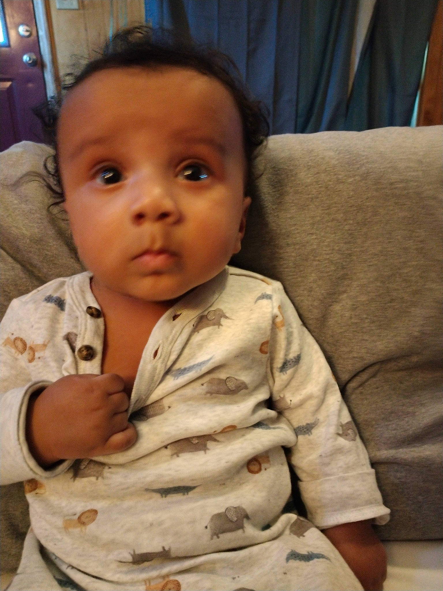 Rowland is registered to the contest to win money with this photo: baby, baby_toddler_clothing, cheek, child, chin, collar, comfort, couch, eyebrow, forehead, linens, lip, mouth, nose, person, sitting, skin, sleeve, smile, thumb