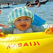 Alessio participe au concours pour gagner de l'argent avec cette photo : baby, boat, child, float, fun, happy, hat, inflatable, lake, outdoor, people, playful, summer, sun_hat, sunlight, swimming, tongue_out, vacation, water, water_sports