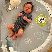 Wyatt joined the competition — help win amazing prizes! baby, infant, child, playpen, crib, lying_down, portrait, face, eyes_open, striped_onesie, milestone_card, two_months, hanging_toy, plush_toy, elephant_pattern, baby_mat, indoor, nursery, safe_sleep_area, wood_floor