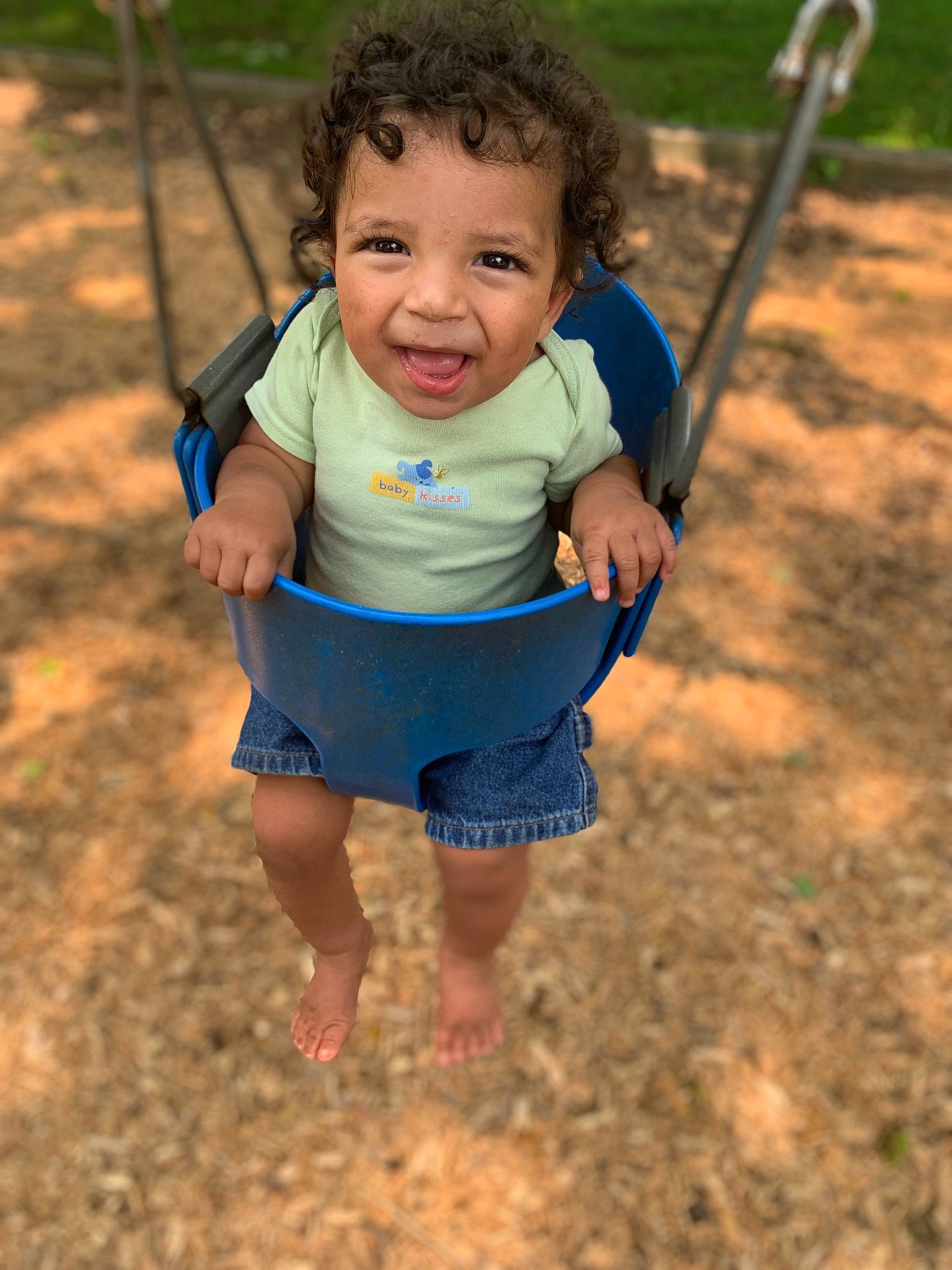 Khalil is registered to the contest to win money with this photo: baby, baby_toddler_clothing, child, eye, face, fun, gesture, grass, happy, head, leaf, leisure, people_in_nature, person, playground, skin, sleeve, smile, swing, toddler