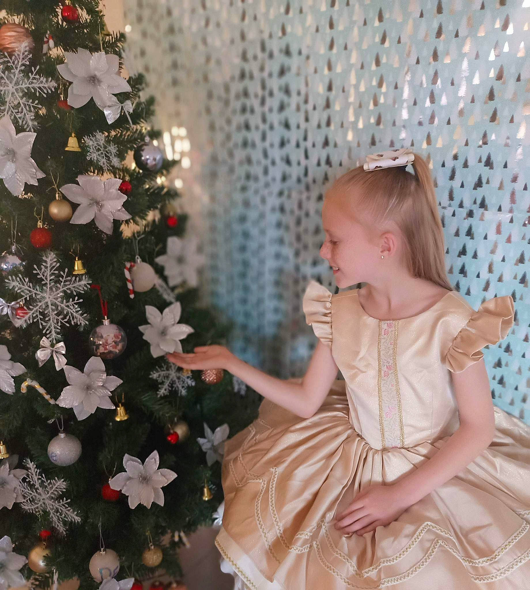 Destiny is registered to the contest to win money with this photo: baby_toddler_clothing, christmas, christmas_decoration, christmas_eve, christmas_ornament, christmas_tree, conifer, day_dress, dress, event, happy, holiday, holiday_ornament, lap, ornament, pattern, person, plant, sitting, toddler