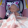 newborn, baby, infant, sleeping, car_seat, blanket, floral_bow, headband, pink, white, portrait, close_up, indoors, seated, harness, safe, cozy, peaceful, vehicle, photography