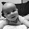 Braxtyn is registered to the contest to win money with this photo: baby, child, infant, smiling, happy, portrait, face, eyes, open_mouth, outdoorless, black_and_white, bed, bedding, pillow, indoors, sitting, leaning, short_sleeves, close_up, photography