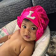 Brittany joined the competition — help win amazing prizes! baby, infant, child, pink_bonnet, headwear, seat, cushion, indoor, sofa, carpet, skin, portrait, looking_at_camera, curious, closeup, young_child, bare_chest, comfortable, home, cute