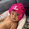 baby, infant, child, pink_bonnet, headwear, seat, cushion, indoor, sofa, carpet, skin, portrait, looking_at_camera, curious, closeup, young_child, bare_chest, comfortable, home, cute