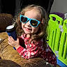 child, sunglasses, flashlight, red_pajamas, curly_hair, smiling, indoor, leather_couch, playpen, toy, happy, person, face, young_child, glasses, holding, colorful, casual, home, portrait
