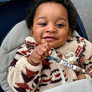 Owen participe au concours pour gagner de l'argent avec cette photo : baby, child, pacifier, fleece_jacket, blanket, hand, face, smile, curly_hair, outdoor, closeup, infant, cute, warm_clothing, person, young_child, accessory, happy, cozy, portrait