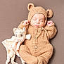 baby, sleeping, plush_toy, knitted_outfit, bear_ears, cute, infant, soft_texture, cozy, peaceful, child, neutral_background, adorable, fuzzy_clothing, resting, toy, portrait, warm_colors, newborn, comfort